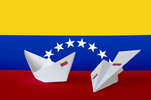 Venezuela flag depicted on paper origami airplane and boat. Oriental handmade arts concept