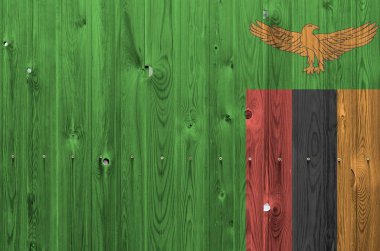 Zambiya bayrağı eski ahşap duvarda parlak boya renkleriyle tasvir edilmiş. Kabataslak arkaplanda desenli pankart