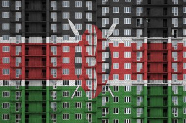 Kenya bayrağı, yapım aşamasında olan çok katlı konut binasının boya renkleriyle resmedilmiş. Büyük tuğla duvar zemininde desenli pankart