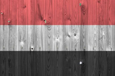 Yemen bayrağı, eski ahşap duvarda parlak boya renkleriyle tasvir edilmiş. Kabataslak arkaplanda desenli pankart