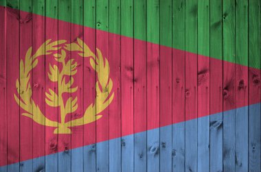 Eritre bayrağı, eski ahşap duvarda parlak boya renkleriyle tasvir edilmiş. Kabataslak arkaplanda desenli pankart
