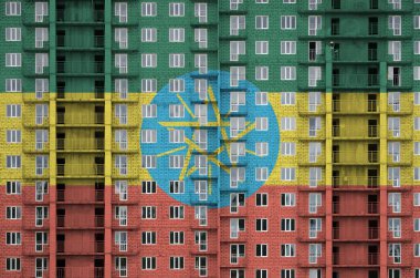 Etiyopya bayrağı, yapım aşamasındaki çok katlı yerleşim yerinin boyalarıyla resmedilmiş. Büyük tuğla duvar zemininde desenli pankart