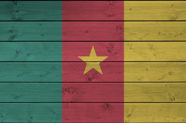 Kamerun bayrağı, eski ahşap duvarda parlak boya renkleriyle tasvir edilmiş. Kabataslak arkaplanda desenli pankart