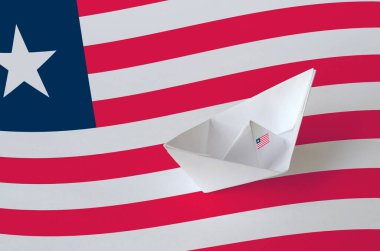 Kağıt origami gemisine yakın plan çizilmiş Liberya bayrağı. Doğu el yapımı sanat konsepti