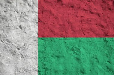 Madagaskar bayrağı eski kabartma duvarda parlak boya renkleriyle resmedilmiş. Kabataslak arkaplanda desenli pankart