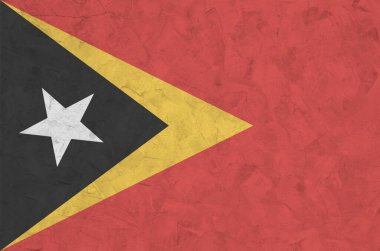 Timor Leste bayrağı, eski kabartma duvarın üzerine parlak boya renkleriyle resmedilmiş. Kabataslak arkaplanda desenli pankart