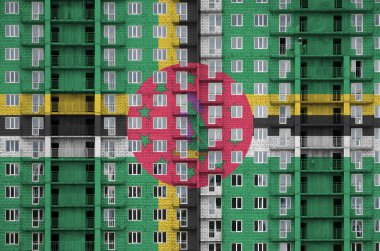 Dominica bayrağı, yapım aşamasındaki çok katlı yerleşim yerinin boyalarıyla resmedildi. Büyük tuğla duvar zemininde desenli pankart