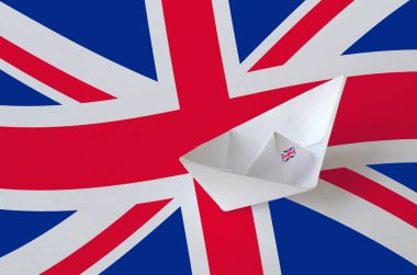 Kağıt origami gemisine yakın plan yapılmış büyük İngiliz bayrağı. Doğu el yapımı sanat konsepti