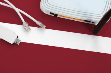 Masada internet rj45 kablo, kablosuz usb wi-fi adaptör ve yönlendirici ile Letonya bayrağı tasvir edilmiştir. İnternet bağlantısı kavramı