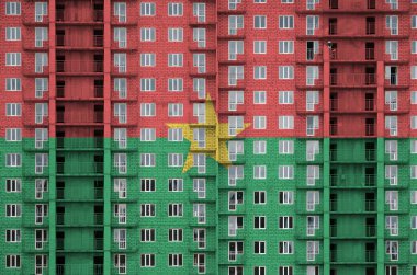 Burkina Faso bayrağı, yapım aşamasında olan çok katlı yerleşim alanının boyalı renkleriyle resmedildi. Büyük tuğla duvar zemininde desenli pankart