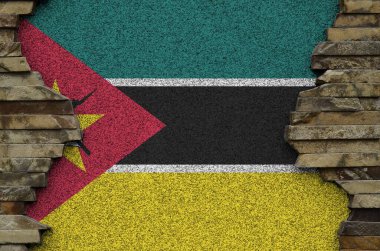 Mozambik bayrağı eski taş duvardaki boya renkleriyle tasvir edilmiş. Kayalık duvar arkaplanındaki desenli pankart