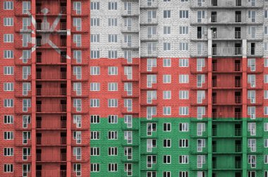 Umman bayrağı, yapım aşamasındaki çok katlı konut binasının boyalarıyla resmedilmiş. Büyük tuğla duvar zemininde desenli pankart