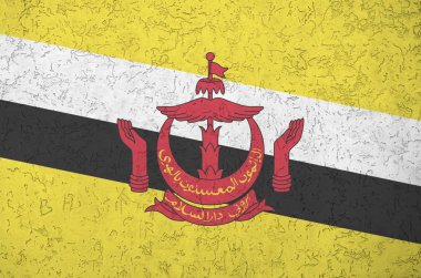 Brunei Darussalam bayrağı eski kabartma duvarına parlak boya renkleriyle resmedilmiş. Kabataslak arkaplanda desenli pankart