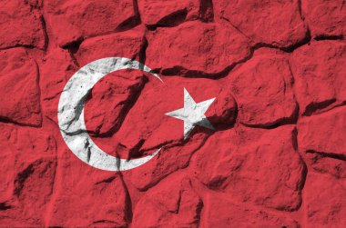 Eski taş duvarlara boyalı renklerle çizilmiş hindi bayrağı. Kayalık duvar arkaplanındaki desenli pankart