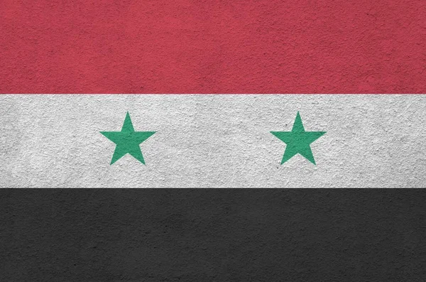 Syria flag depicted in bright paint colors on old relief plastering wall close up. Textured banner on rough background