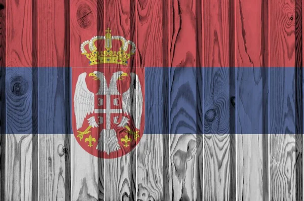 Serbia flag depicted in bright paint colors on old wooden wall close up. Textured banner on rough background