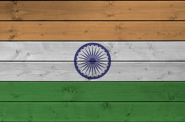 India flag depicted in bright paint colors on old wooden wall close up. Textured banner on rough background