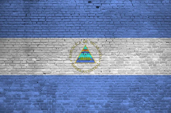 古いレンガの壁にペイント色で描かれたニカラグアの旗が閉じます 大きなレンガの壁の石積みの背景にテクスチャバナー — ストック写真
