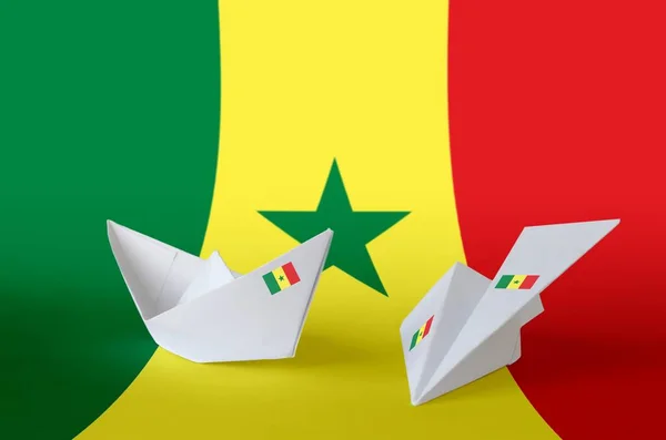 Senegal flag depicted on paper origami airplane and boat. Oriental handmade arts concept