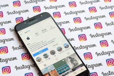 Kağıt instagram afişinde akıllı telefon ekranında Apple resmi instagram hesabı.