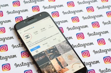 Kağıt instagram pankartıyla akıllı telefon ekranında Chanel resmi instagram hesabı.