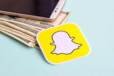 Snapchat kağıt logosu dolar ve akıllı telefon dolu zarflarla dolu.