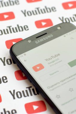 Samsung akıllı telefon ekranında küçük youtube logoları ve yazıtları olan bir Youtube uygulaması. Youtube, Google 'ın yan kuruluşu ve Amerika' nın en popüler video paylaşım platformudur.