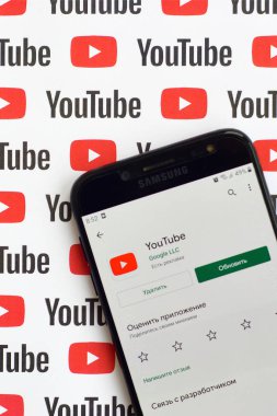 Samsung akıllı telefon ekranında küçük youtube logoları ve yazıtları olan bir Youtube uygulaması. Youtube, Google 'ın yan kuruluşu ve Amerika' nın en popüler video paylaşım platformudur.