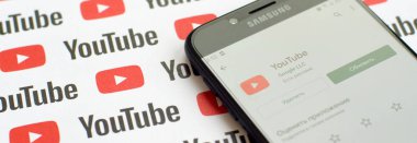 Samsung akıllı telefon ekranında küçük youtube logoları ve yazıtları olan bir Youtube uygulaması. Youtube, Google 'ın yan kuruluşu ve Amerika' nın en popüler video paylaşım platformudur.