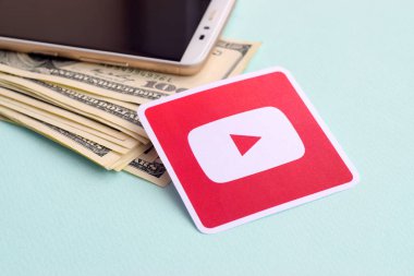 Youtube kağıt logosu dolar ve akıllı telefon dolu zarflarla dolu.