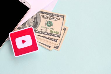Youtube kağıt logosu dolar ve akıllı telefon dolu zarflarla dolu.
