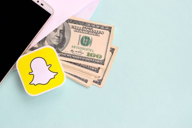 Snapchat kağıt logosu dolar ve akıllı telefon dolu zarflarla dolu.