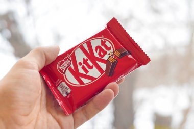 Kit Kat çikolatası, erkek eli karlı arka planda. Kit Kat, Birleşik Krallık 'ta Rowntree' s of York tarafından yaratıldı ve şimdi küresel olarak Nestle tarafından üretiliyor.