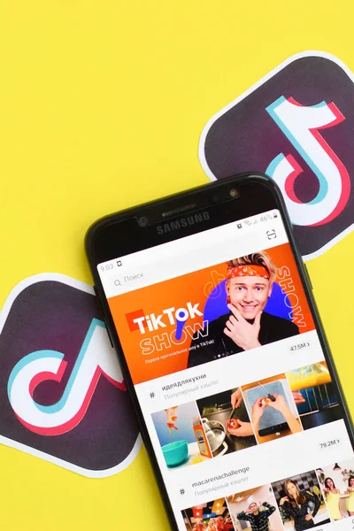 Aplikasi Tiktok pada layar telepon pintar samsung pada latar belakang kuning. TikTok adalah layanan jejaring sosial berbagi video populer yang dimiliki oleh ByteDance — Stok Foto
