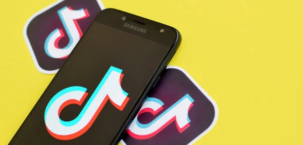 Tiktok logo on samsung smartphone screen on yellow background. TikTok is a popular video-sharing social networking service owned by ByteDance — 스톡 사진