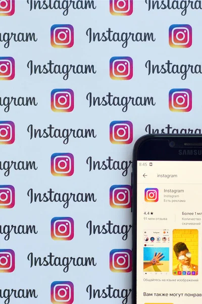 Instagram app auf samsung smartphone screen auf banner mit kleinen instagram-logos. instagram ist ein amerikanischer Foto- und Video-Sharing-Dienst für soziale Netzwerke von facebook inc — Stockfoto