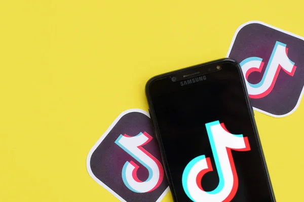 Logo Tiktok pada layar telepon pintar samsung pada latar belakang kuning. TikTok adalah layanan jejaring sosial berbagi video populer yang dimiliki oleh ByteDance — Stok Foto
