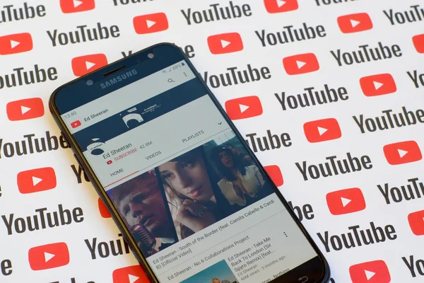 Ed Sheeran official youtube channel on smartphone screen on paper youtube background. — Stock Photo, Image