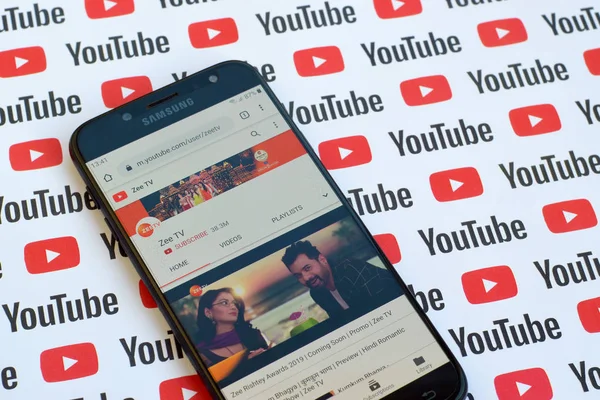 Zee TV official youtube channel on smartphone screen on paper youtube background. — Stock Photo, Image