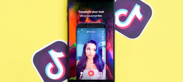 Aplicación Tiktok en pantalla Samsung smartphone sobre fondo amarillo. TikTok es un popular servicio de redes sociales para compartir videos propiedad de ByteDance —  Fotos de Stock