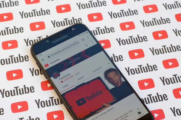 Pewdiepie official youtube channel on smartphone screen on paper youtube background. — Stock Photo, Image