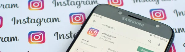 Aplikacja Instagram na ekranie smartfona samsung na banerze z małymi logo Instagrama. Instagram to amerykański serwis społecznościowy do udostępniania zdjęć i filmów przez Facebook Inc — Zdjęcie stockowe