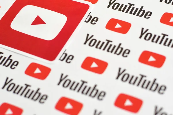 Stiker logo Youtube pada pola dicetak di atas kertas dengan logo youtube kecil dan prasasti. YouTube adalah anak perusahaan Google dan platform berbagi video paling populer di Amerika — Stok Foto