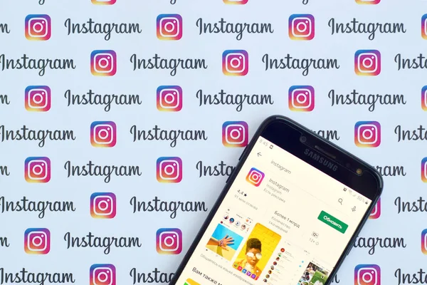 Instagram app auf samsung smartphone screen auf banner mit kleinen instagram-logos. instagram ist ein amerikanischer Foto- und Video-Sharing-Dienst für soziale Netzwerke von facebook inc — Stockfoto