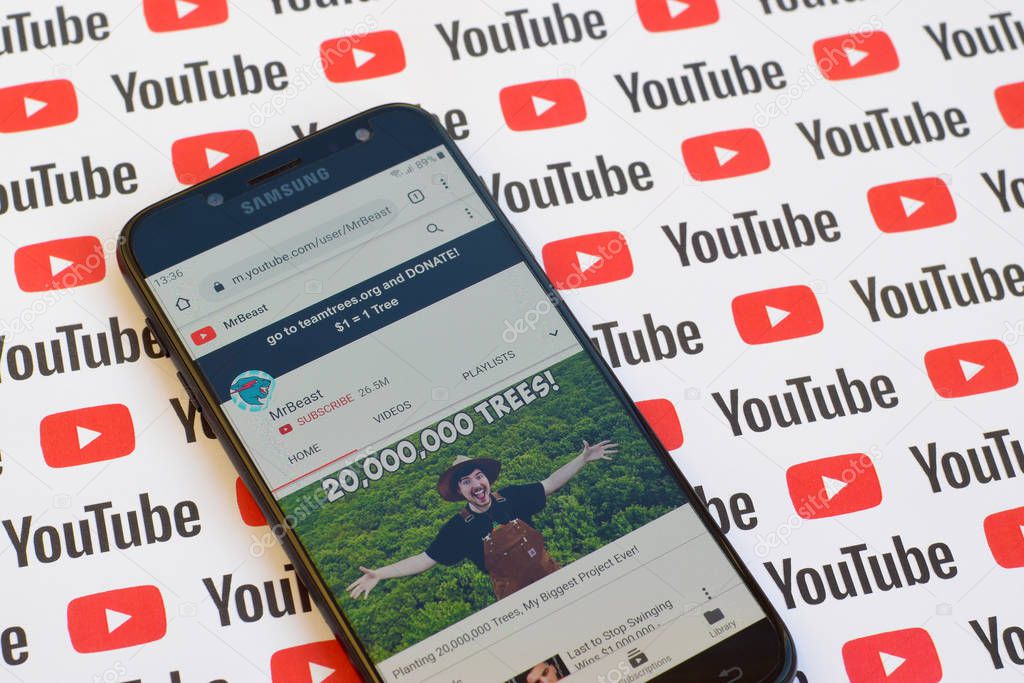 NY, USA - DECEMBER 4, 2019: MrBeast official youtube channel on smartphone screen on paper youtube background.