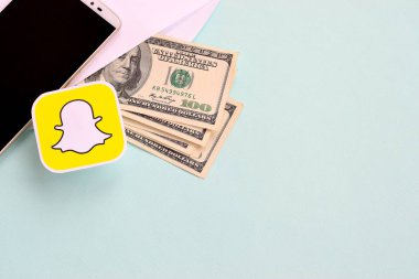 Snapchat kağıt logosu dolar ve akıllı telefon dolu zarflarla dolu.