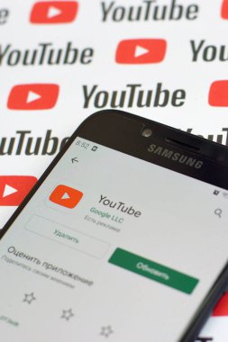 Samsung akıllı telefon ekranında küçük youtube logoları ve yazıtları olan bir Youtube uygulaması. Youtube, Google 'ın yan kuruluşu ve Amerika' nın en popüler video paylaşım platformudur.