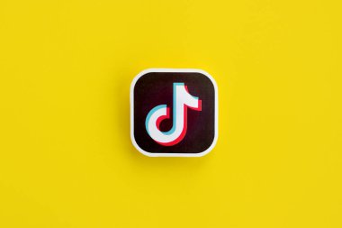 Sarı arka planda Tiktok kağıt logosu. Tiktok Bytedance 'in sahip olduğu popüler bir video paylaşım sosyal ağ hizmetidir.