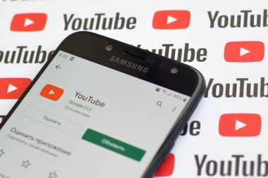 Samsung akıllı telefon ekranında küçük youtube logoları ve yazıtları olan bir Youtube uygulaması. Youtube, Google 'ın yan kuruluşu ve Amerika' nın en popüler video paylaşım platformudur.
