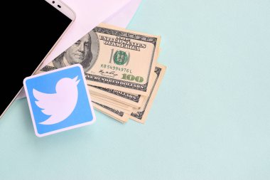 Twitter kağıt logosu dolar ve akıllı telefon dolu.
